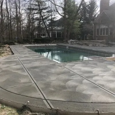 New broom-finished concrete deck around a rectangular pool