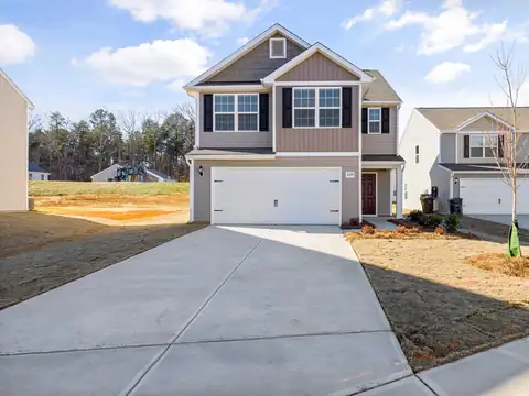 Wide new concrete driveway in front of a two-story house