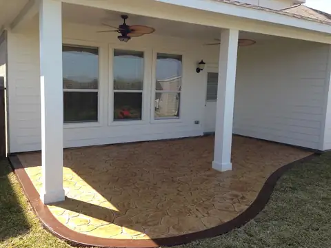 Covered back patio with a stamped slate concrete floor and a colored border